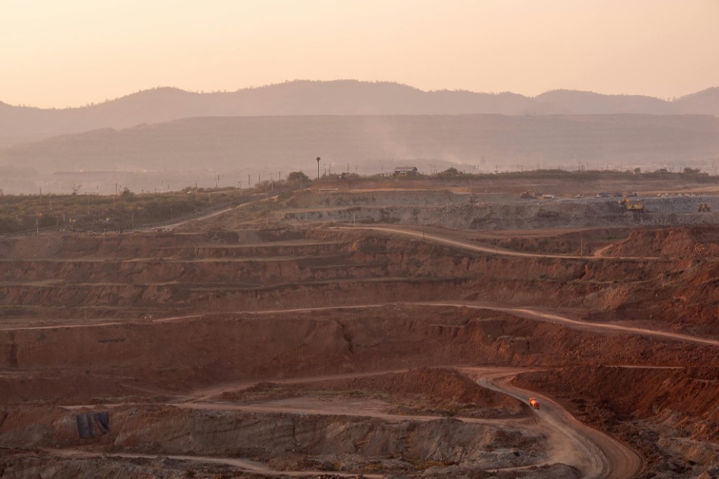 Open pit mine at sunset with terraced excavation and haul roads